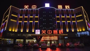 A hotel with a modern facade, illuminated by vertical lights, and a sign indicating it is a hotel. - Guanzhong Hotel (Tongguan)