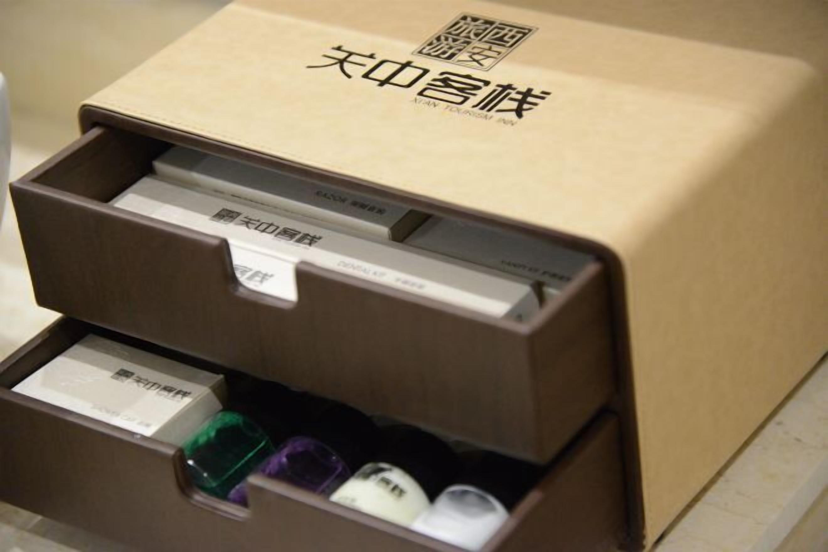 A brown box with Chinese characters and a barcode, containing several items including a white box and a green bottle.