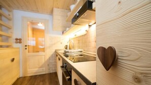 A kitchen with wooden cabinets, a sink, and a heart-shaped decoration on the wall.