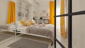 Camera da letto moderna con un letto, un armadio a muro e un ampio specchio.