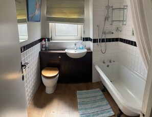 Enjoy a refreshing bathroom experience with a toilet, sink, and separate bathtub.
