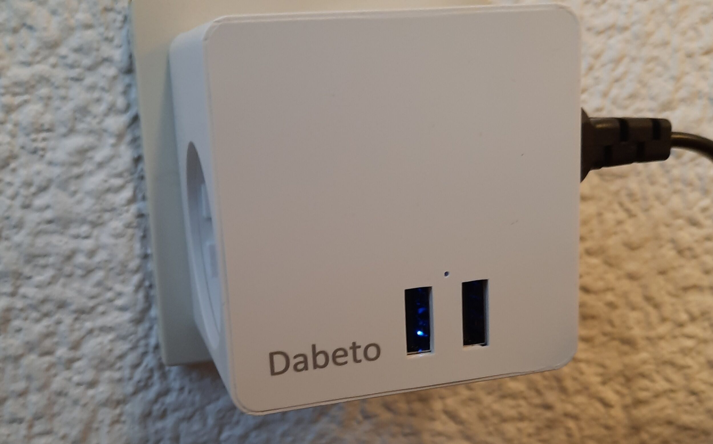 A white power strip with two USB ports and a label reading "Dabeto".