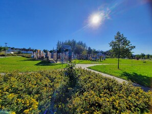 Un parc avec un ciel dégagé, un sentier et un panneau d’information.