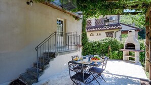 A patio with a table set for dining, a stone staircase, and a brick oven. - VILLAROSA SPICCIANO Exclusive Villa with pool (Fivizzano/Spicciano)