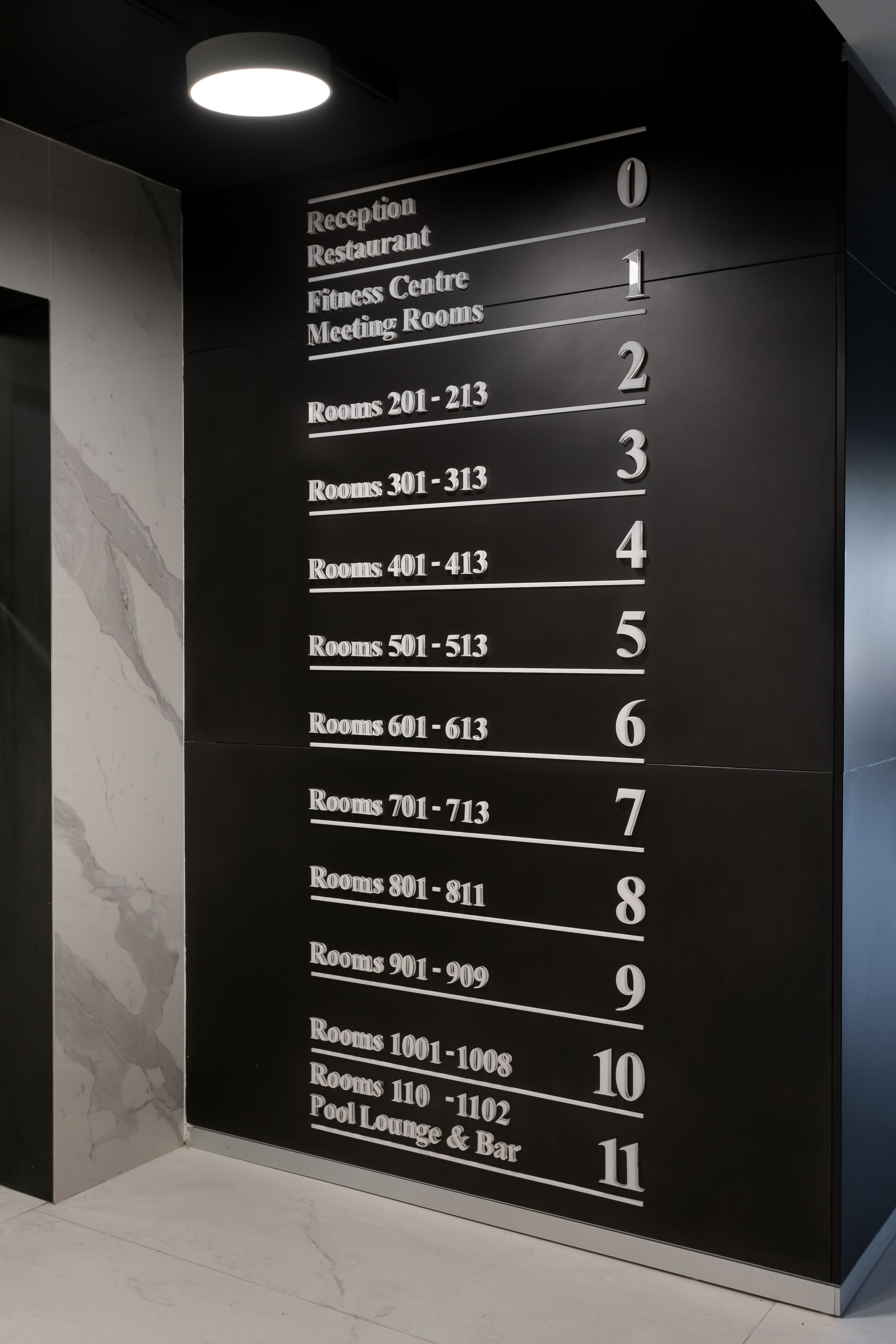 A hotel directory wall listing rooms and amenities.