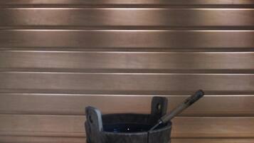 Relax in a traditional sauna with a wooden bench and bucket.