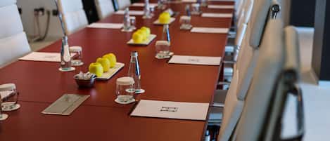 A conference room with a long table, white chairs, and name cards.