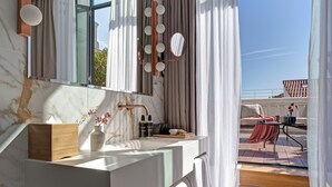 A modern bathroom with a marble countertop, a large mirror, and a view of the outdoor terrace. - UMusic Hotel Madrid (Madrid)