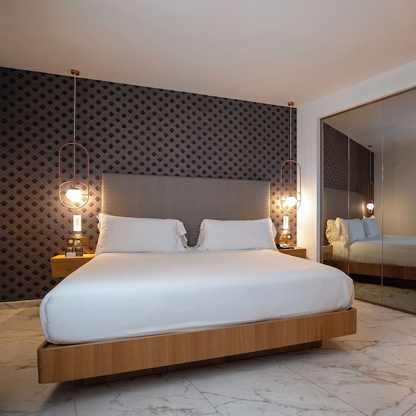 A modern hotel room with a large bed, wooden headboard, and a patterned wall. - UMusic Hotel Madrid (Madrid)