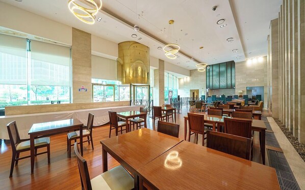 A spacious dining area with wooden tables and chairs, large windows, and a modern ceiling design. - Niagara Hotel (Seoul)