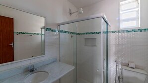 A bathroom with a glass-enclosed shower, a sink, and a toilet. - Hotel Fazenda Santa Helena (Simao Pereira)