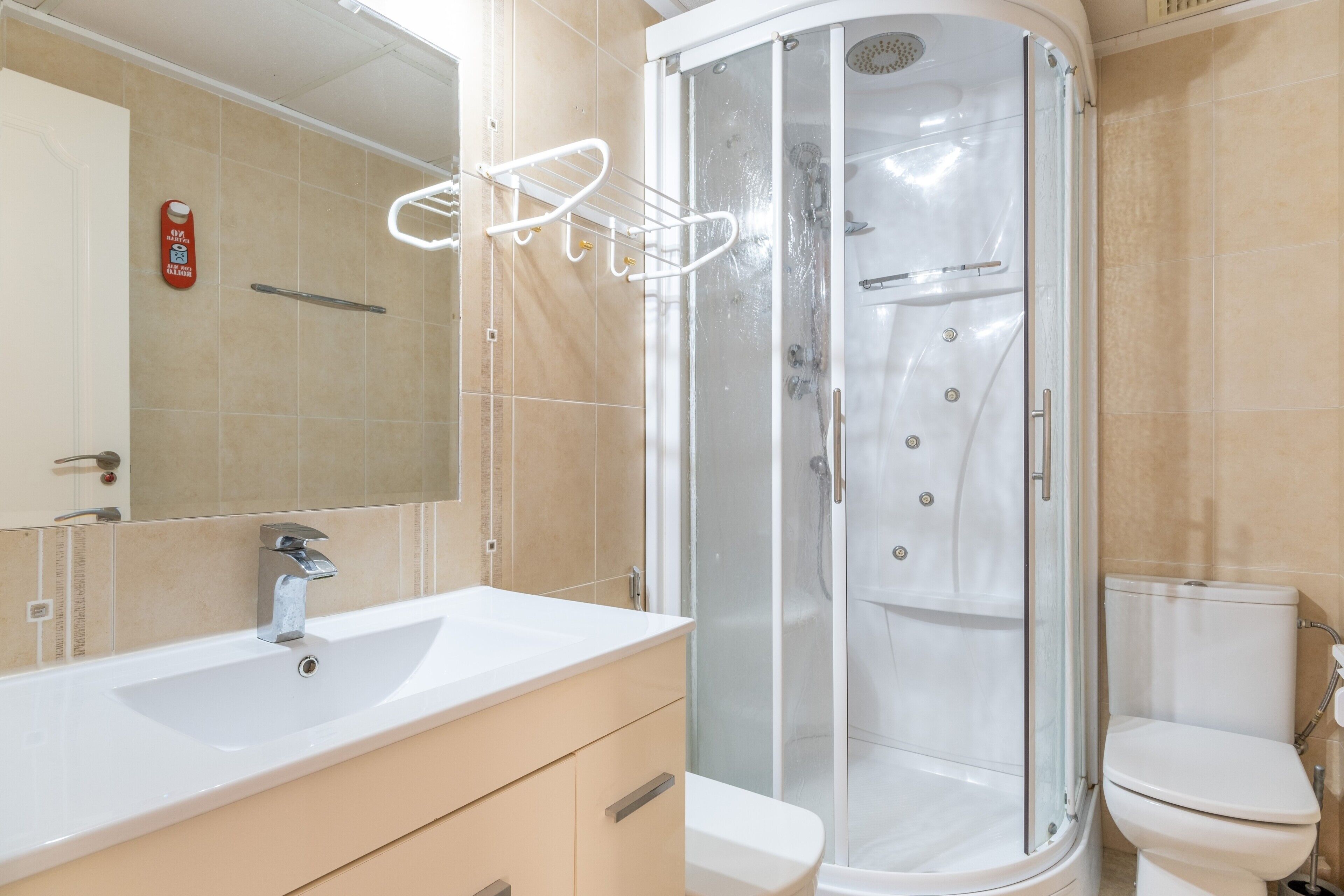 Un baño con cabina de ducha, lavabo e inodoro.