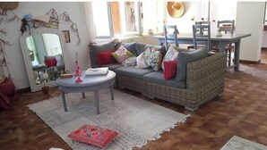 Una sala de estar acogedora con un sofá gris, una mesa de centro redonda y un tapete estampado.