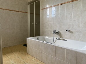 Een bad, een haardroger, handdoeken, toiletpapier