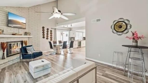 A modern living room with a fireplace, a dining area, and a kitchen in the background. - Luxury Vacation Home in Phoenix - Pool - Sleeps 17 (Phoenix)
