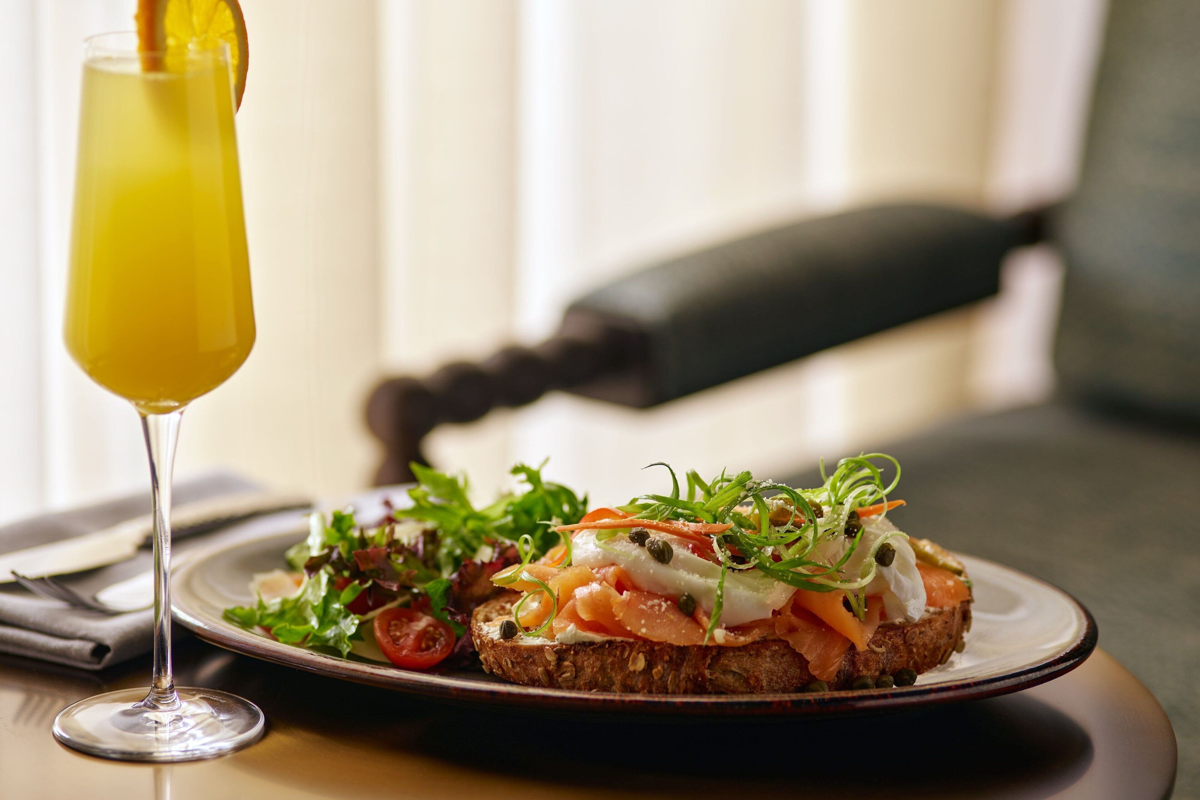 Ein Teller Essen mit einem Glas Orangensaft auf einem Tisch.