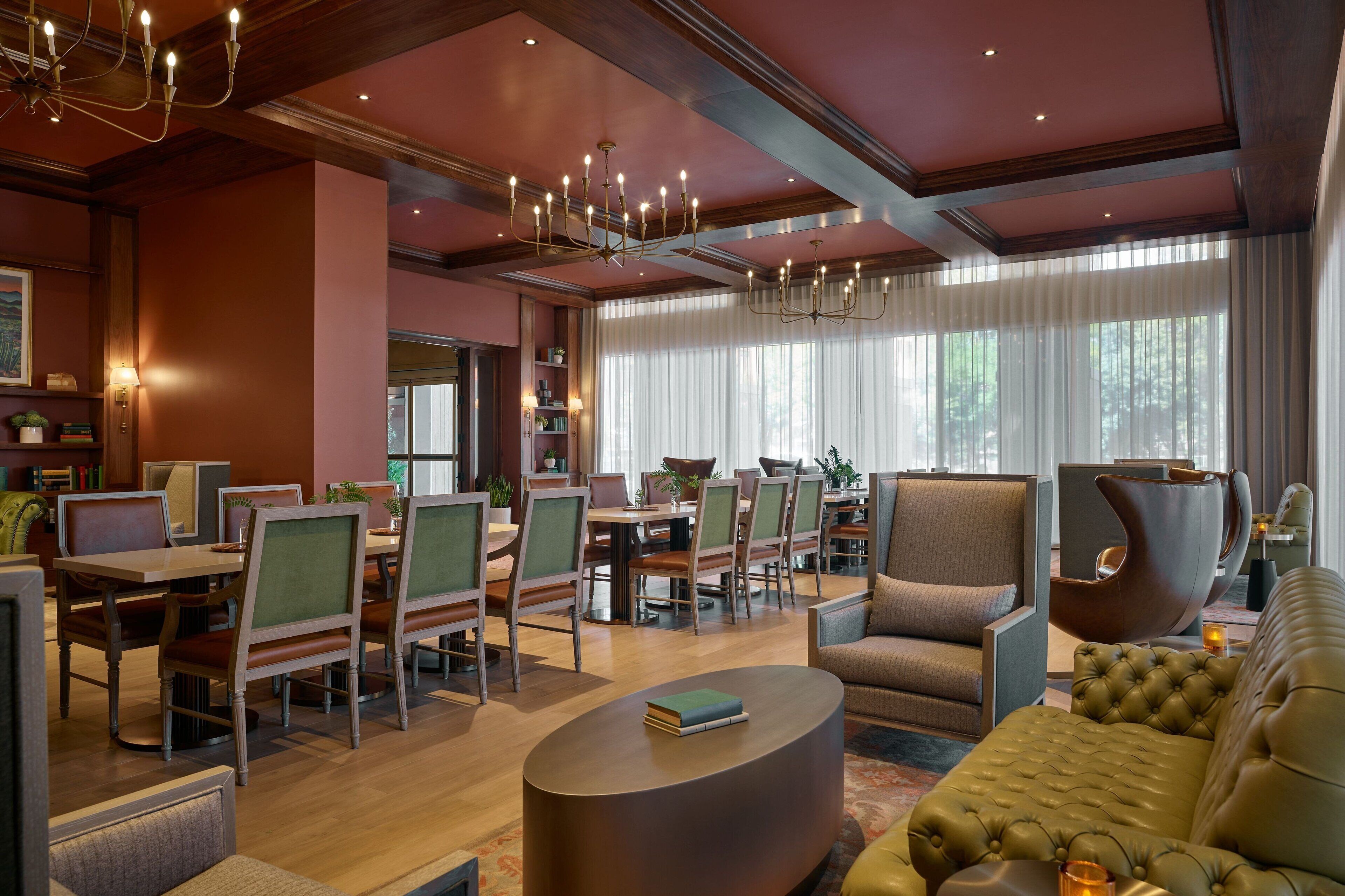 Un hall d’hôtel comprenant un espace repas, des sièges et un lustre.