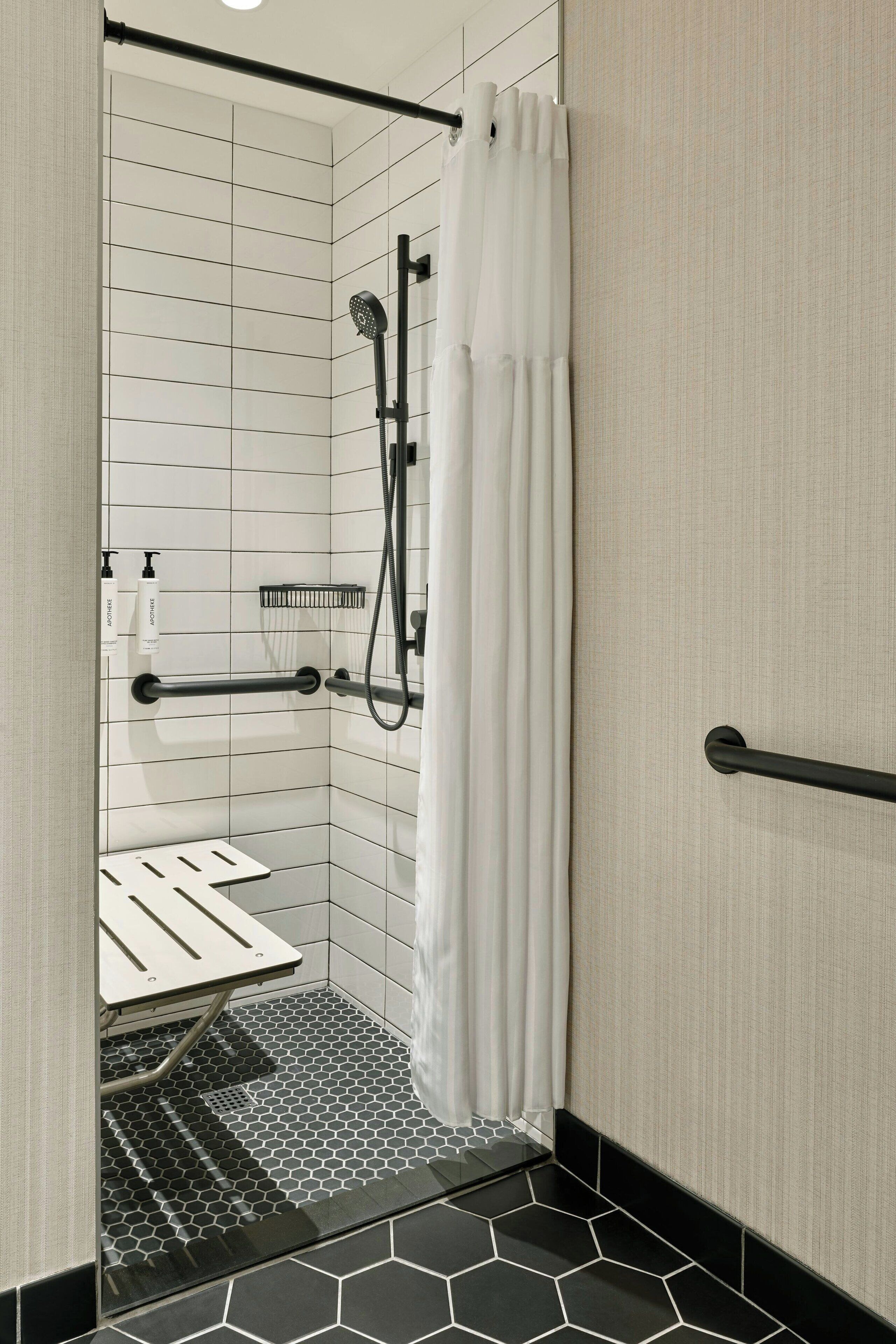 A modern bathroom with a shower, a toilet, and a sink.