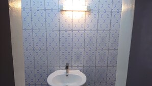 Un bagno con un lavandino bianco e piastrelle blu decorate.
