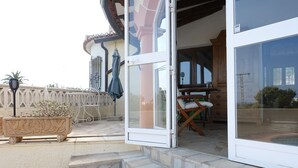A patio with outdoor furniture, a wooden table, and a chair. - Cosy villa with private pool and sea and mountain views, in Denia (Denia)
