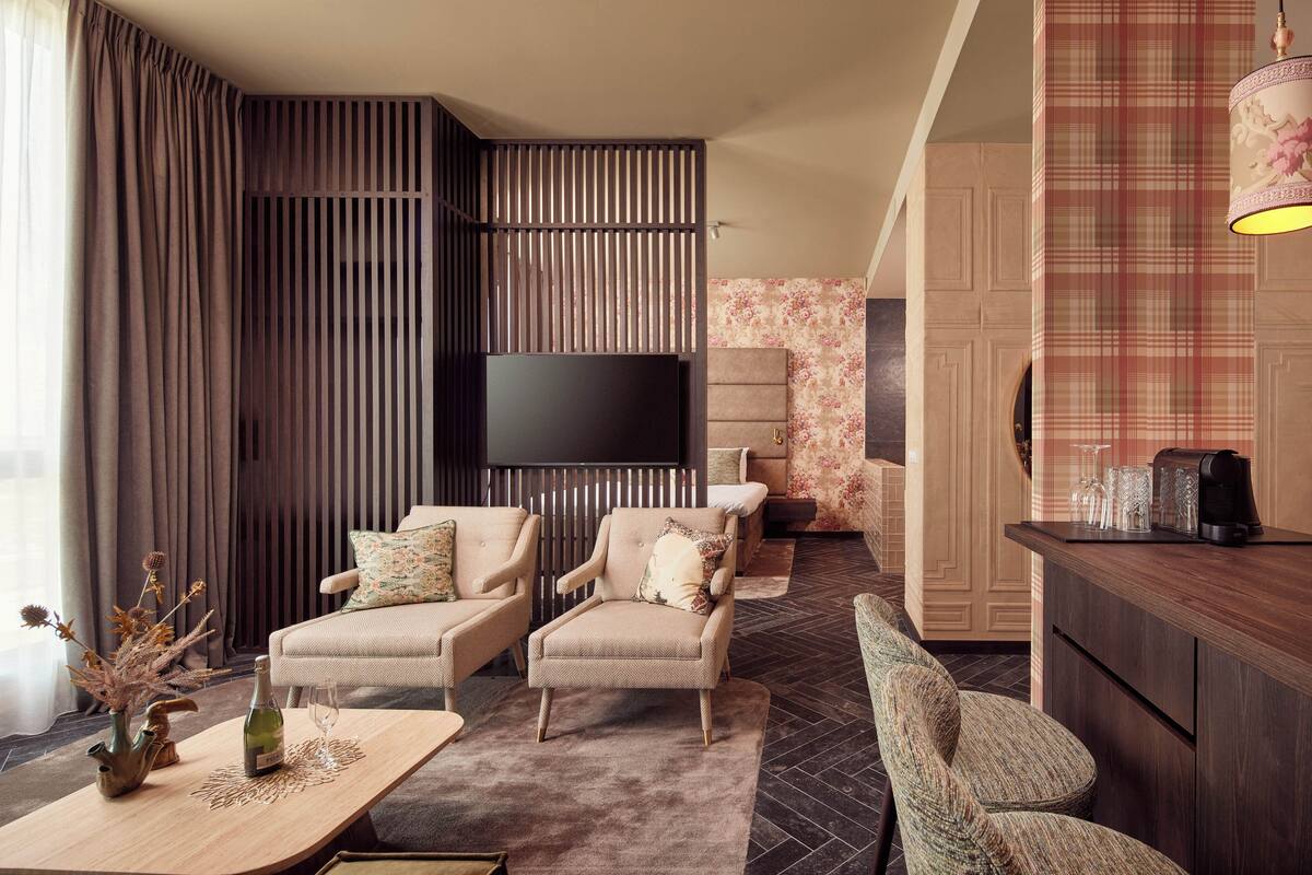 Ein modernes Wohnzimmer mit einer Couch, Sesseln, einem Couchtisch und einem Fernseher.