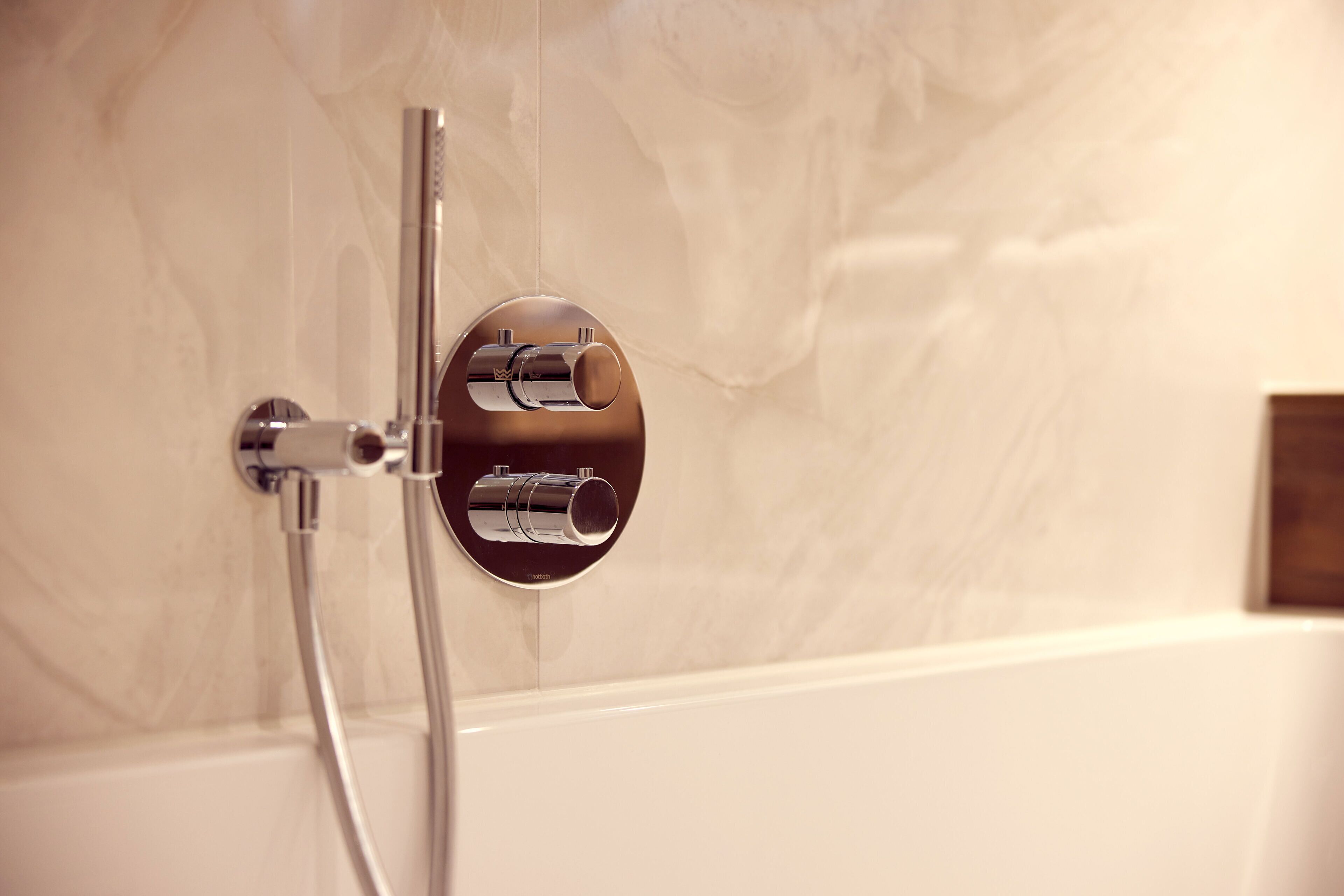 Een moderne badkamer met een in de muur gemonteerde douche en bedieningspaneel.