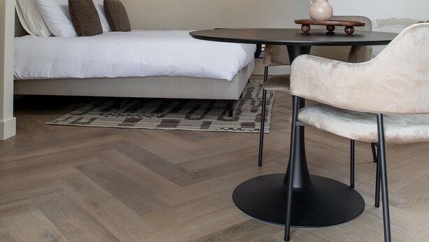 Une chambre moderne avec un grand lit, une table à manger et une chaise.