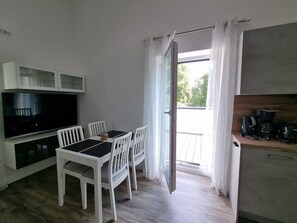 A compact kitchen with a dining area, a TV, and a coffee machine. - "achterwasser" - Moderne Ferienwohnung in Varel (Varel)