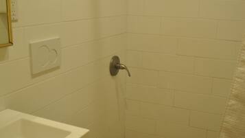 Un baño con ducha, inodoro y lavamanos.
