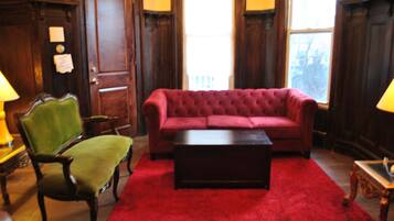 A room with a red sofa, a green armchair, and a wooden coffee table.