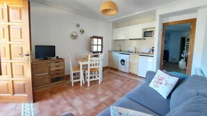 A compact living space with a kitchenette, a dining area, and a sofa.
