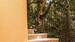 A set of outdoor stairs with patterned steps leading up to a door, surrounded by greenery. - Rooftop Terrace and Pool Near Mamitas Beach (Playa del Carmen)