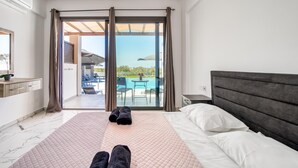 A bedroom with a bed, a nightstand, a window, and a view of an outdoor pool area.
