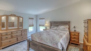 Una camera da letto con un letto grande, una cassettiera in legno e uno specchio.