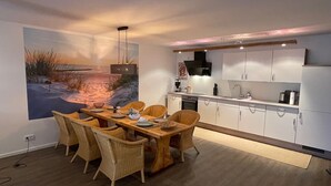 Een moderne keuken met witte kasten, een ingebouwde oven en een magnetron.