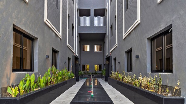 Un edificio moderno con un patio central, que presenta un diseño geométrico con una fuente de agua.