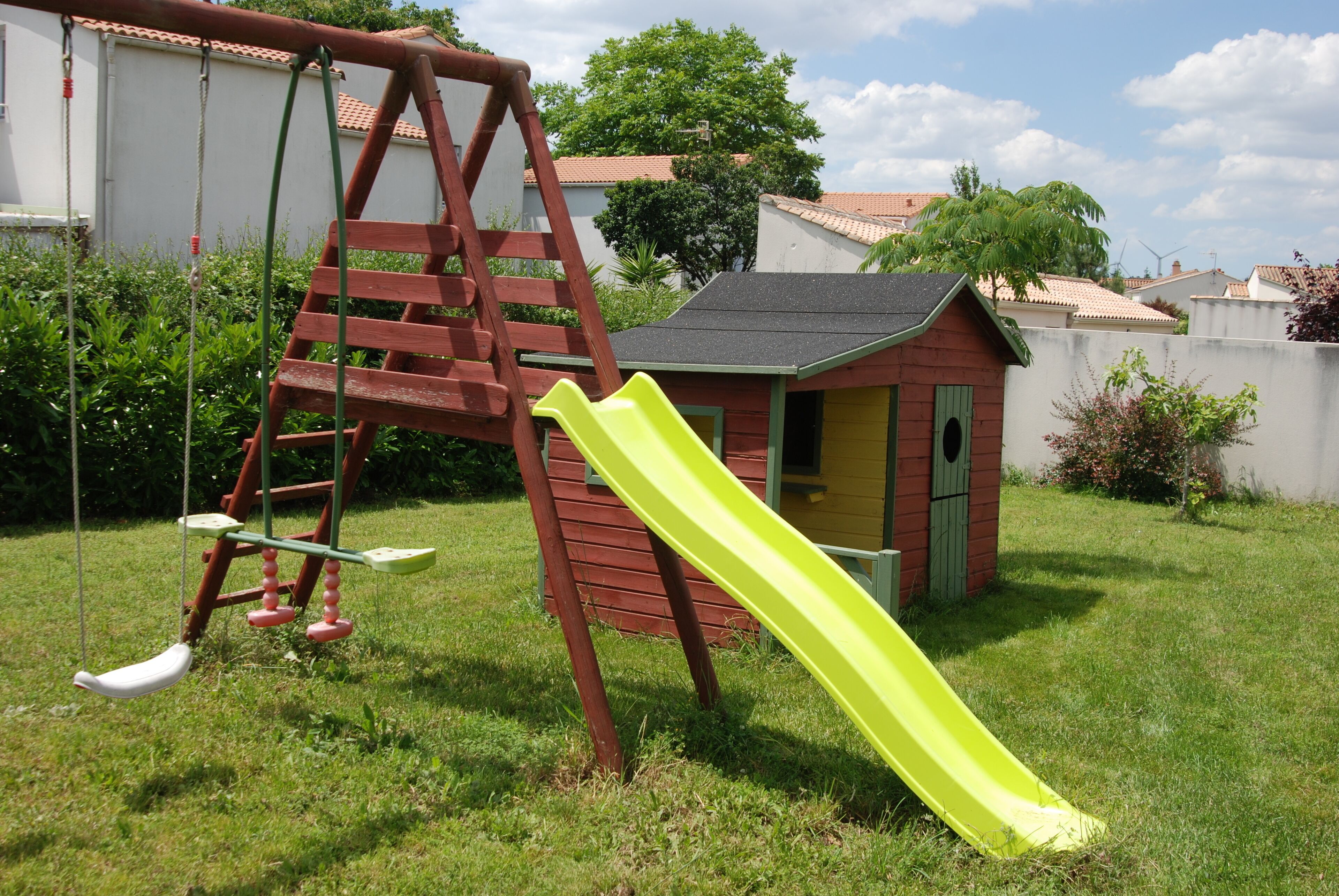 A swing set and a slide in a backyard.