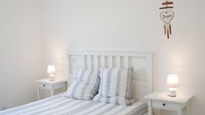 A neatly made bed with striped bedding, two bedside tables with lamps, and a wall decoration with the word "Dream". - Maison Individuelle Avec Jardin (Angles)