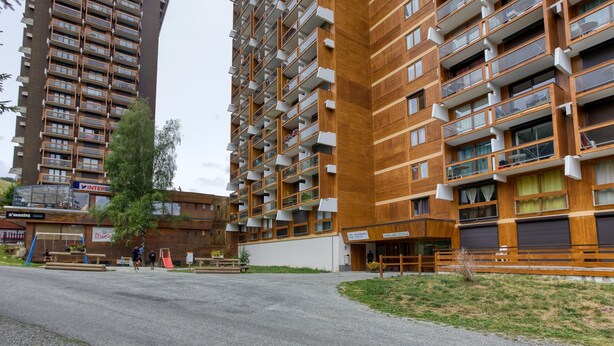 A modern apartment building with multiple balconies, a playground, and a small outdoor seating area. - Soyouz-Vanguard 10 - Studio Apartment, Sleeps 4 (Villarembert)