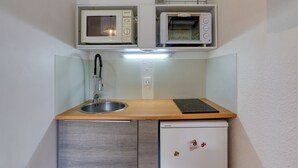 A compact kitchenette with a built-in microwave, toaster, and refrigerator. - Soyouz-Vanguard 10 - Studio Apartment, Sleeps 4 (Villarembert)