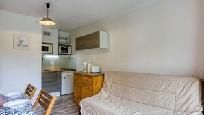 A compact living space with a kitchenette, a dining area, and a sofa. - Soyouz-Vanguard 10 - Studio Apartment, Sleeps 4 (Villarembert)