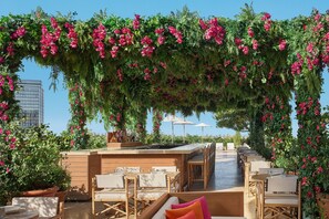 Una piscina al aire libre, camas de piscina con cargo, sombrillas