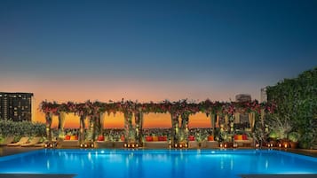 Una piscina al aire libre, camas de piscina con cargo, sombrillas