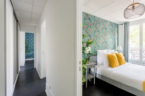 Un dormitorio moderno con cama, escritorio y ventana.