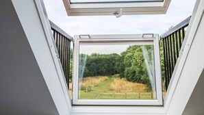 A skylight with a view of a grassy field and trees. - The Stable at Warren House (Market Rasen)