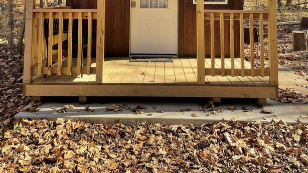 A small wooden cabin with a porch, a door, and a sign that reads "Chestnut."