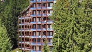 A multi-story hotel with balconies, surrounded by trees and a parking area. - 100m from resort center, 8th floor, balcony, tv, 30m², Les Arcs (Les Arcs)