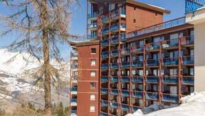 A multi-story hotel with balconies, surrounded by snow-covered mountains. - 100m from resort center, 8th floor, balcony, tv, 30m², Les Arcs (Les Arcs)