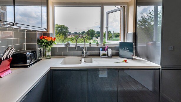 A modern kitchen with a large window, a built-in sink, and a toaster. - Charming 2-bed Apartment in Windsor - Free Parking (Windsor)