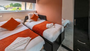 A hotel room with two beds, a large mirror, and a view of the outside. - Charming 2-bed Apartment in Windsor - Free Parking (Windsor)